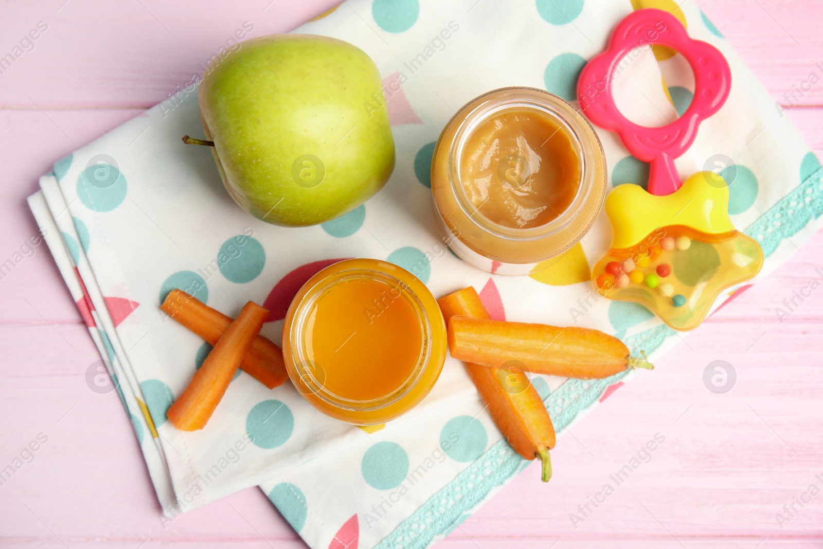 Photo of Healthy baby food in jars and fresh ingredients on pink wooden table, flat lay