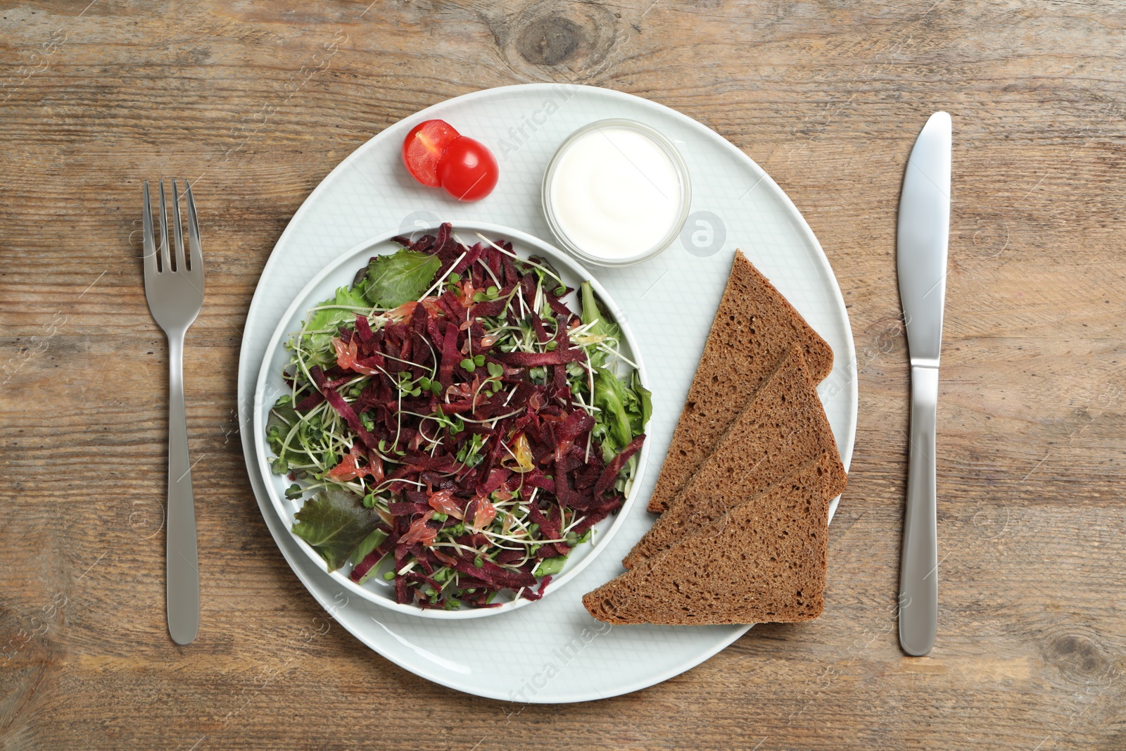 Photo of Delicious carrot salad served on wooden table, flat lay