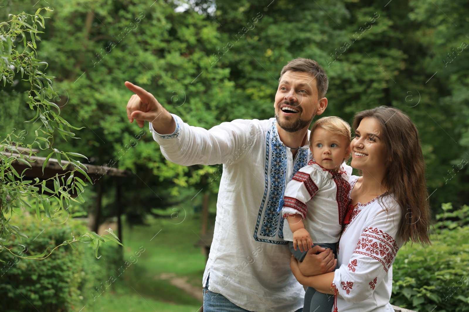 Photo of Happy family in Ukrainian national clothes outdoors