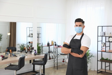 Photo of Professional stylist with protective mask in salon, space for text. Hairdressing services during Coronavirus quarantine