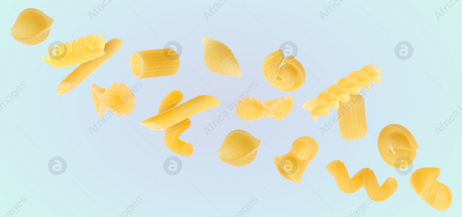 Image of Different types of pasta flying on dusty light blue background