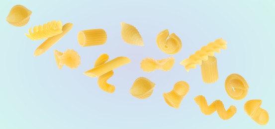 Different types of pasta flying on dusty light blue background