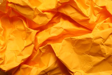 Texture of orange crumpled paper as background, closeup