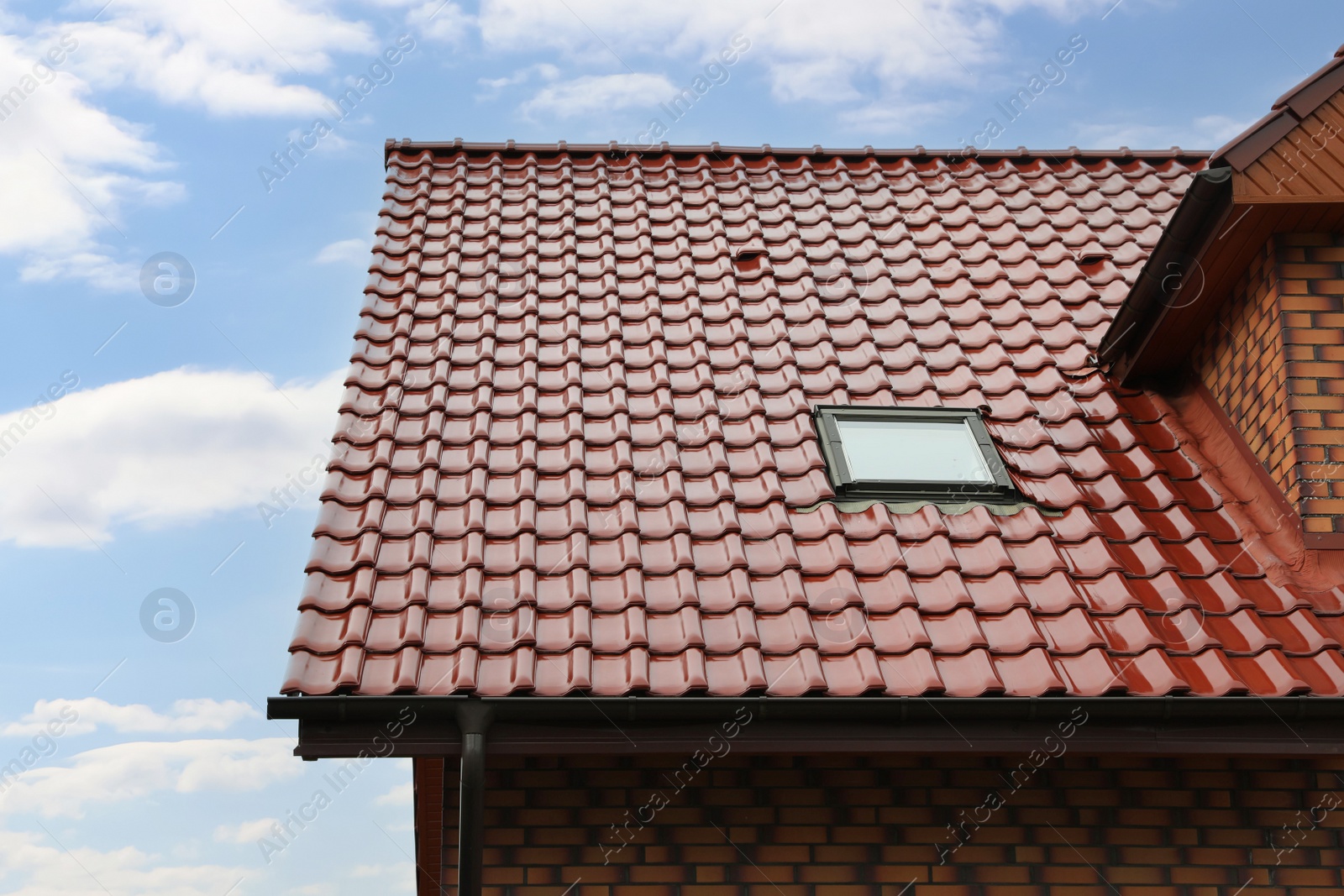 Photo of Beautiful house with red roof against blue sky