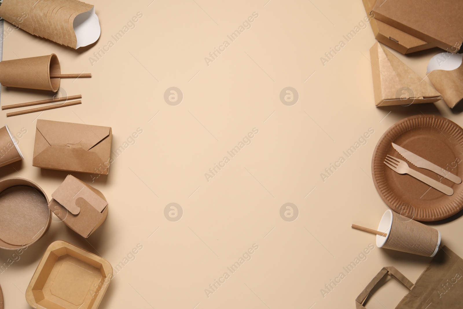 Photo of Eco friendly food packaging. Paper containers and tableware on beige background, flat lay. Space for text