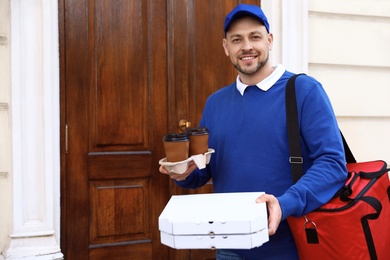 Male courier with order at entrance. Food delivery service