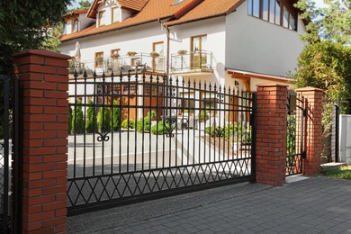 Photo of Metal gates near beautiful estate on sunny day