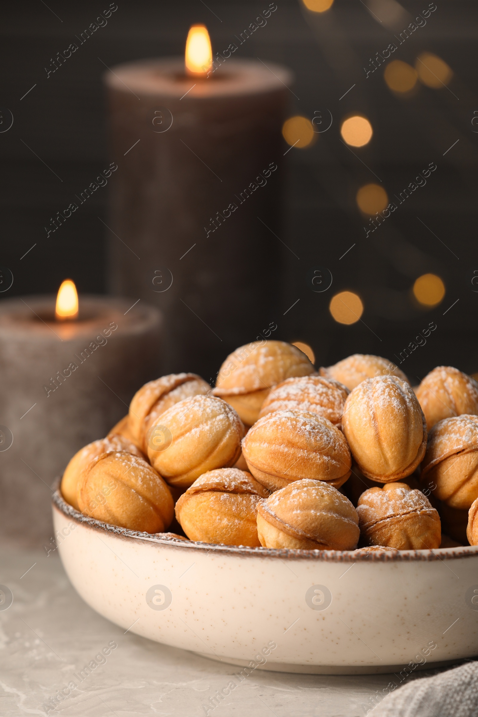 Photo of Bowl of delicious nut shaped cookies on grey table, closeup