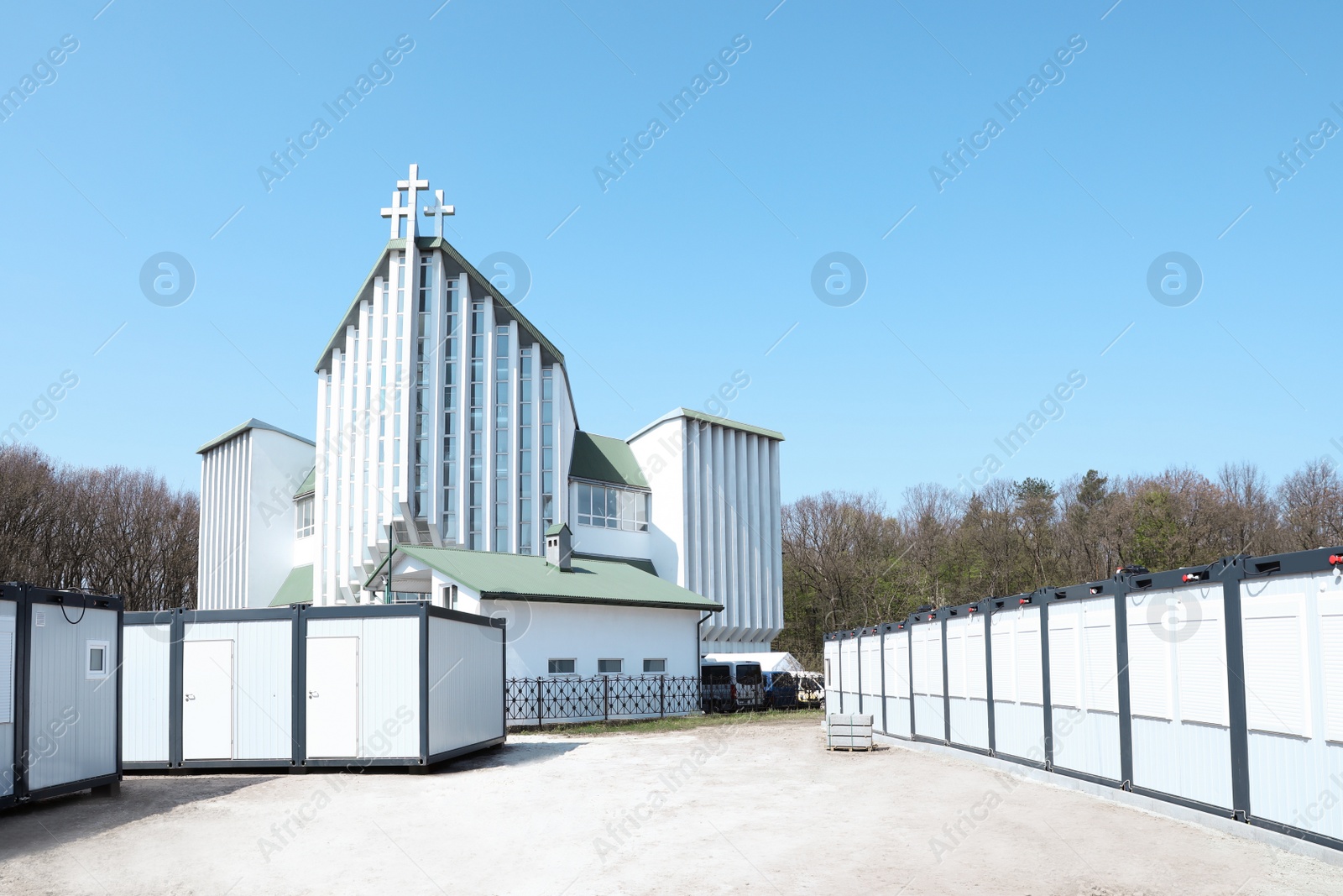 Photo of New modular houses for internally displaced persons and modern church outdoors