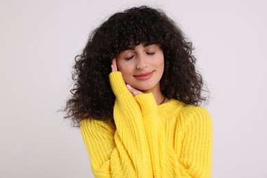 Photo of Young woman in stylish yellow sweater on white background