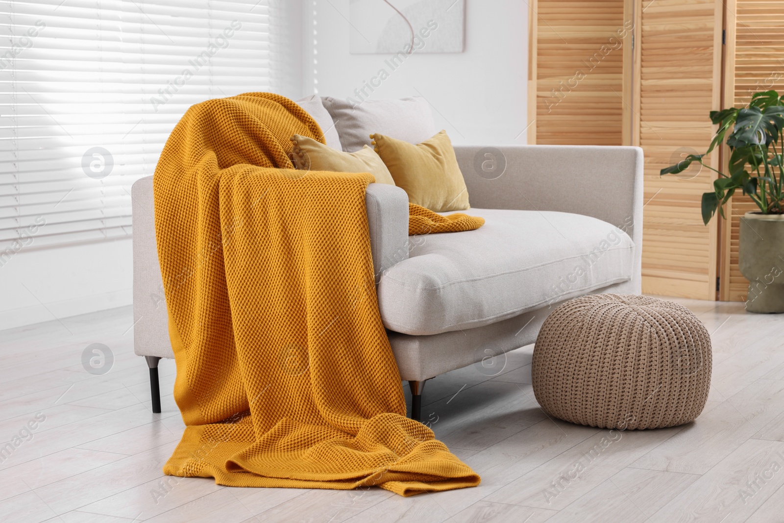 Photo of Cozy orange plaid on sofa in living room