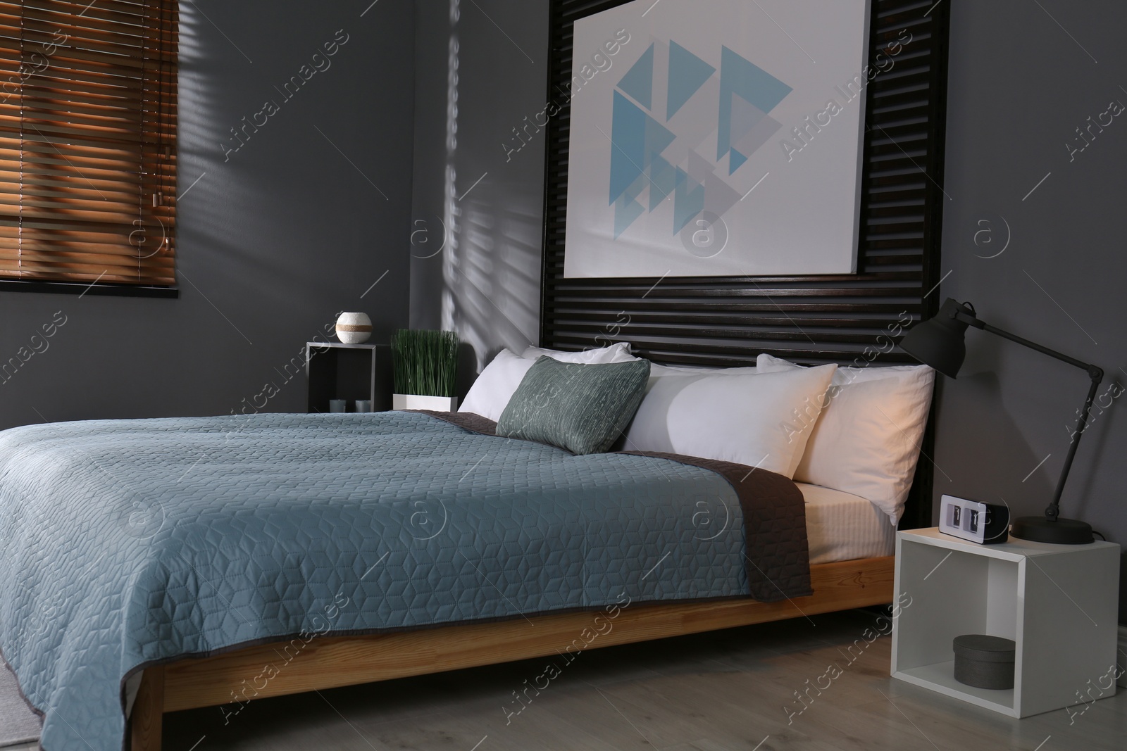 Photo of Comfortable bedroom with picture on decorative wall. Interior design