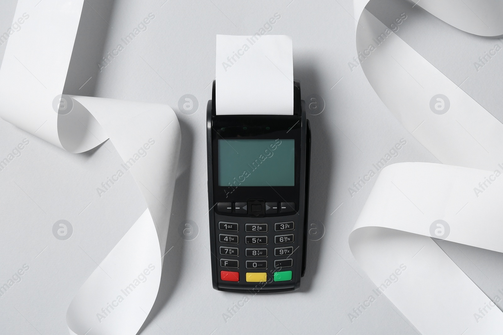 Photo of Payment terminal with thermal paper for receipt on light grey background, top view