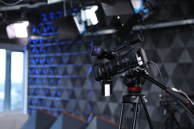 Photo of Modern video recording studio with professional equipment, focus on camera