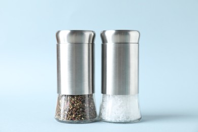 Photo of Salt and pepper shakers on light background