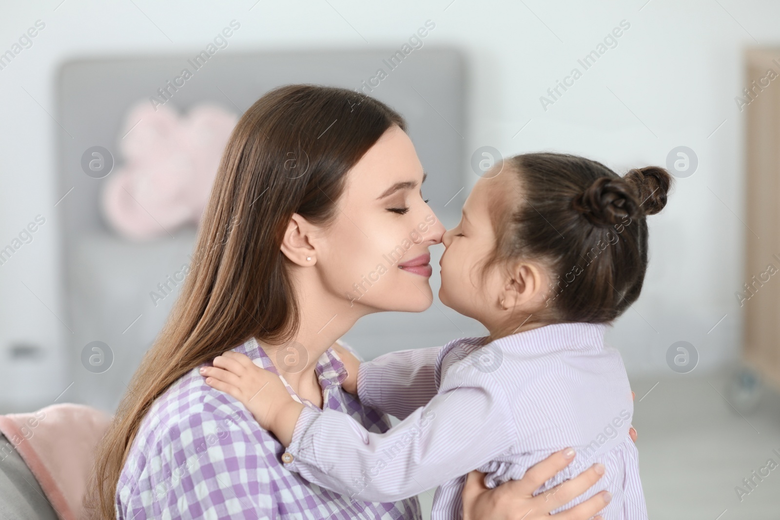 Photo of Young mother with little daughter at home