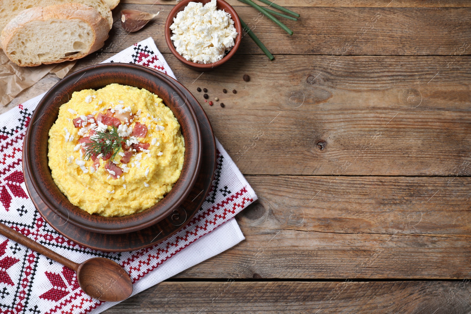 Photo of Traditional Ukrainian banosh served with brynza and pork cracklings on wooden table, flat lay. Space for text