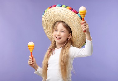 Cute girl in Mexican sombrero hat dancing with maracas on purple background