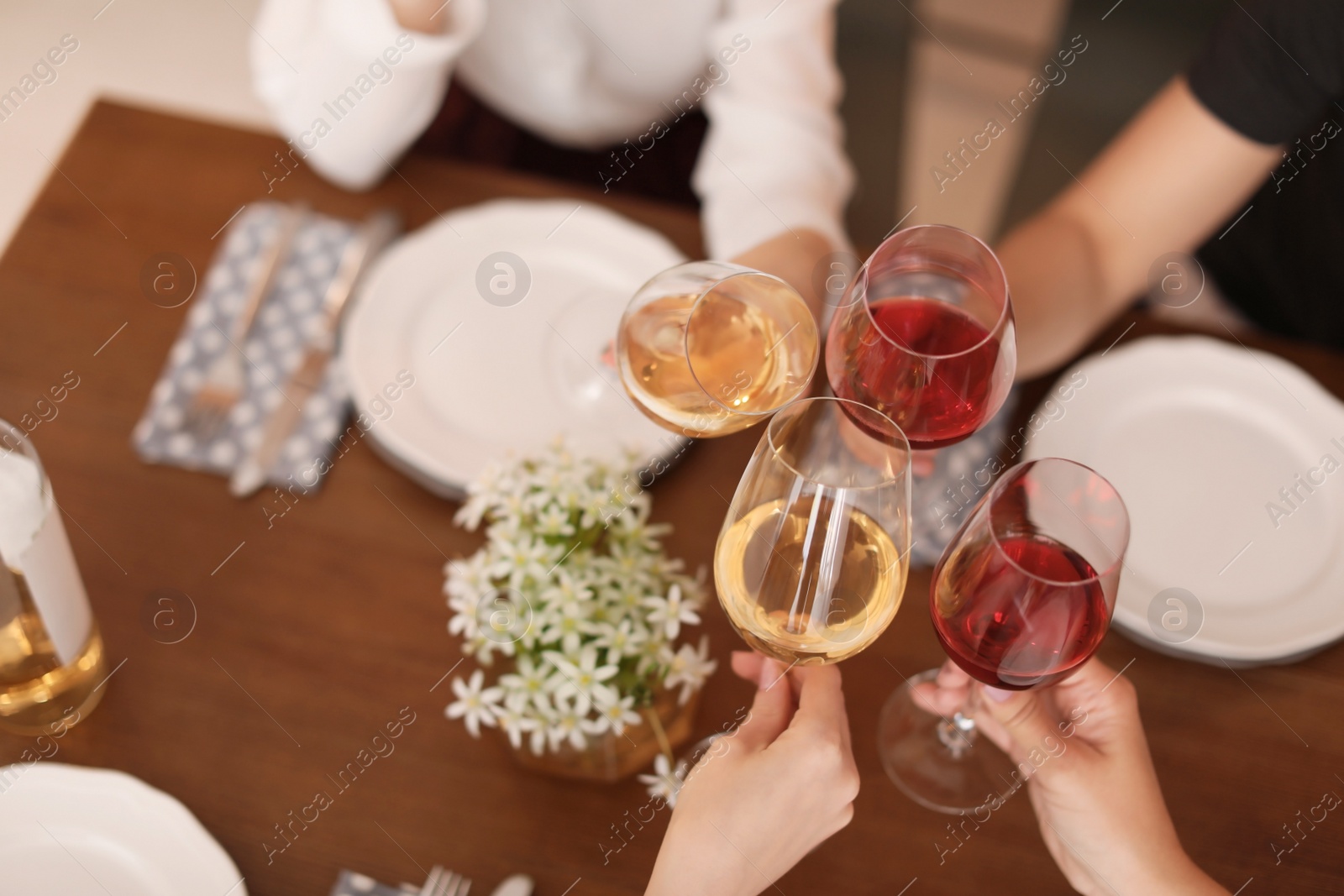 Photo of Young people with glasses of delicious wine at table