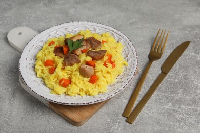 Photo of Delicious pilaf with meat served on light grey table