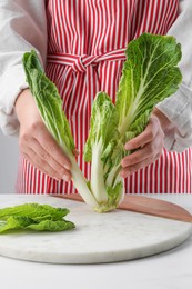 Photo of Woman with fresh cabbage at white table, closeup