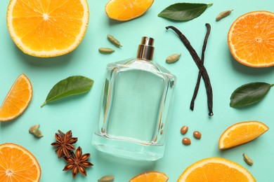 Flat lay composition with bottle of perfume and fresh citrus fruits on turquoise background