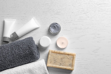 Photo of Flat lay composition with spa cosmetics and towels on wooden background
