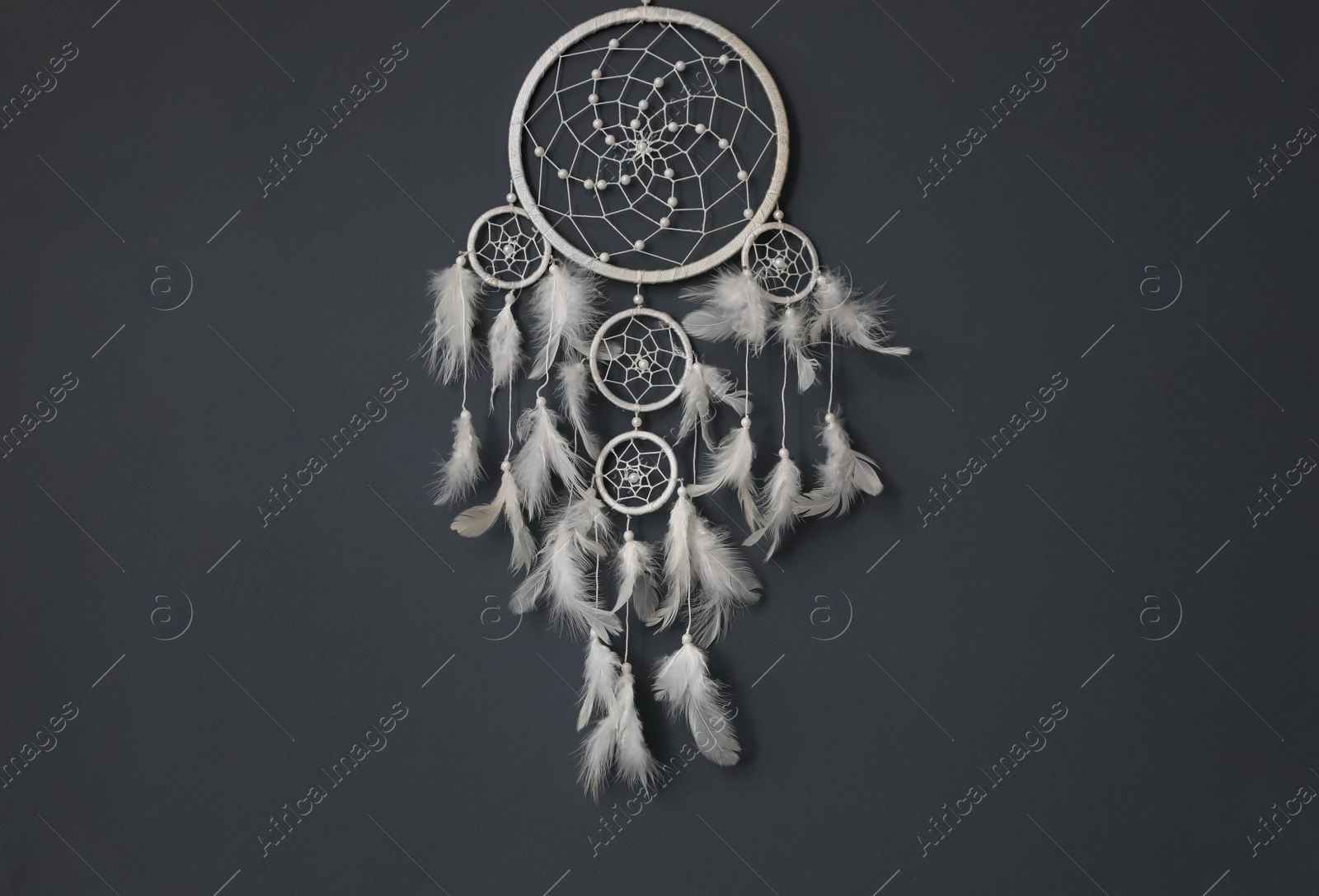 Photo of Beautiful dream catcher hanging on black wall