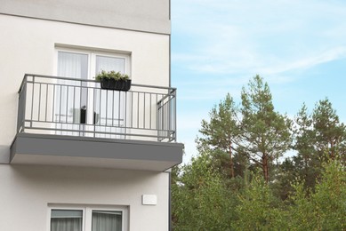 Beautiful beach house with balcony and trees outdoors