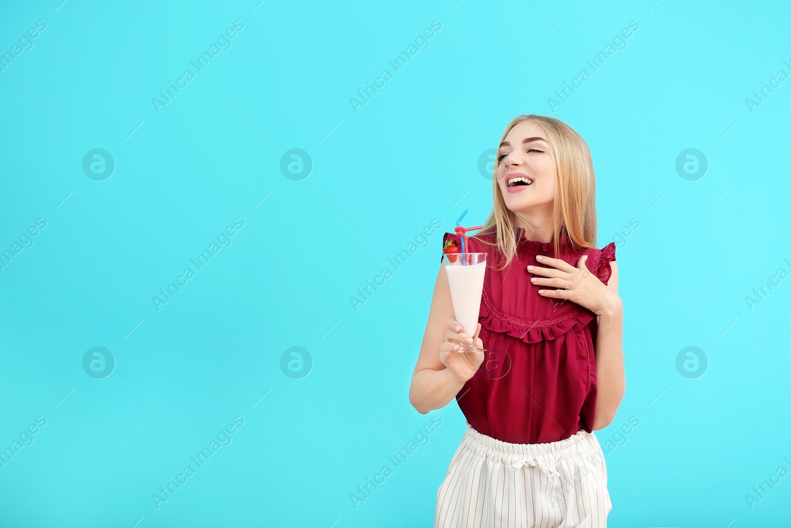 Photo of Young woman with glass of delicious milk shake on color background