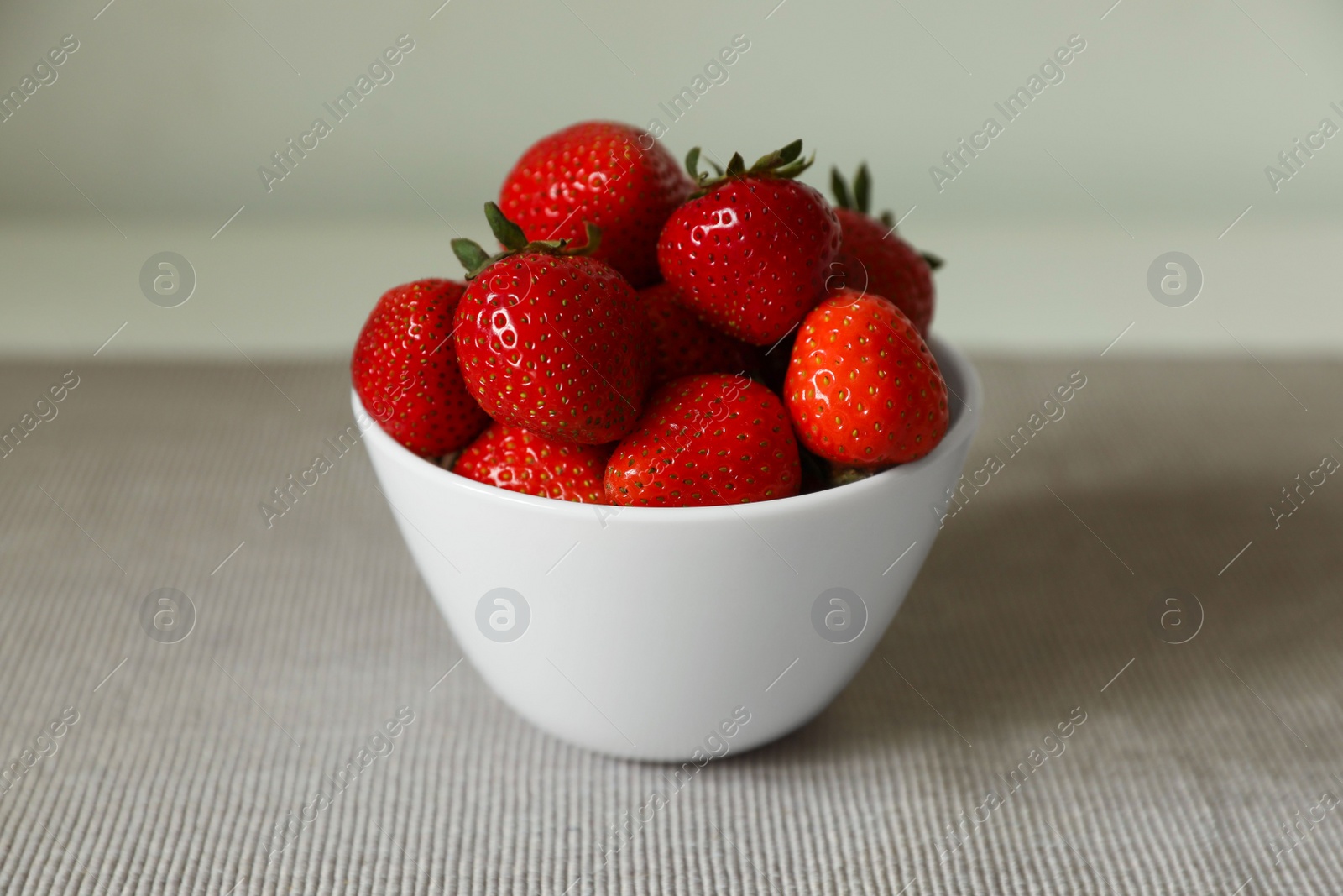 Photo of Fresh juicy strawberries in bowl on table, closeup