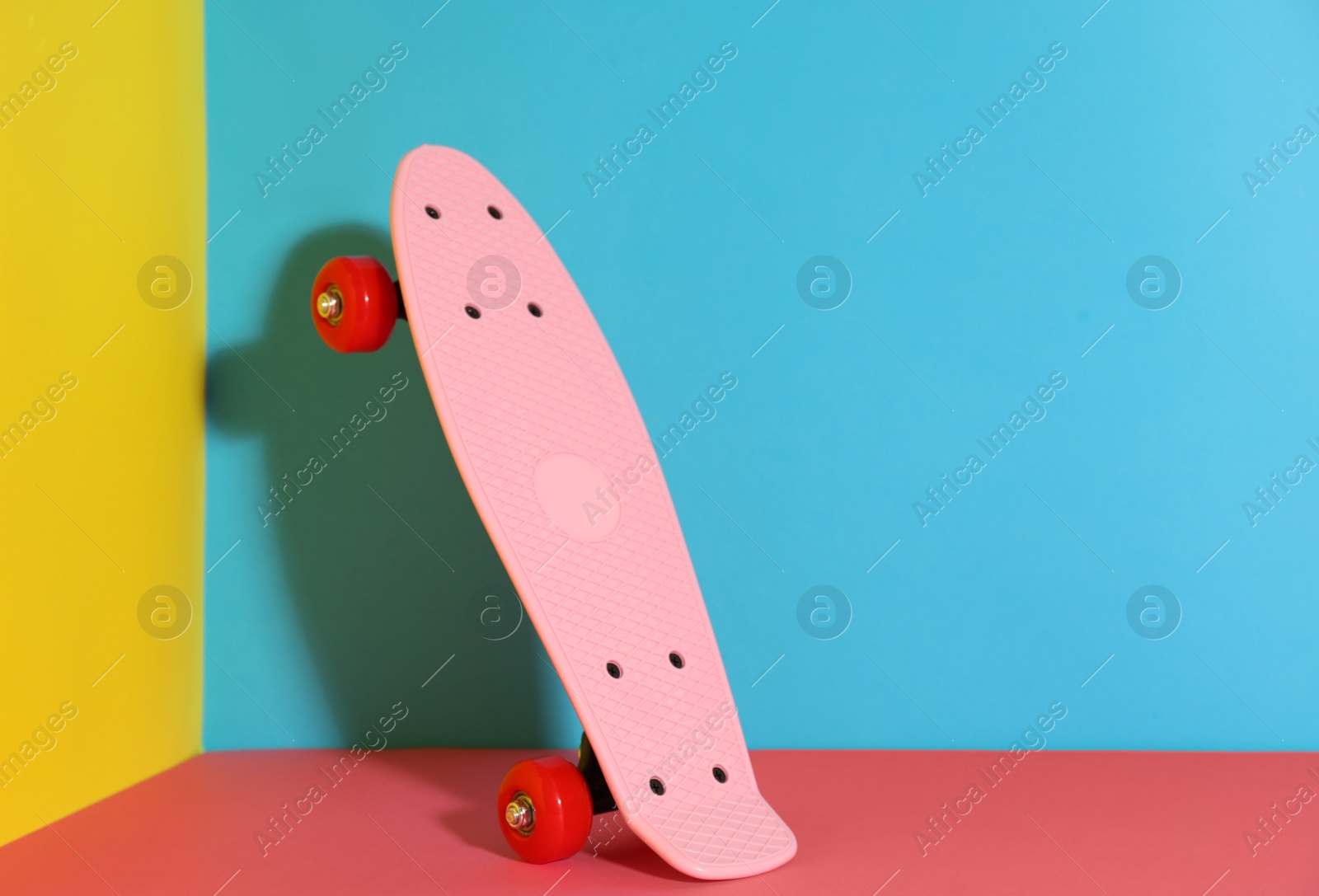 Photo of Pink skateboard on color background. Space for text