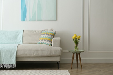 Stylish beige sofa in living room interior