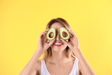 Photo of Portrait of young beautiful woman with ripe delicious avocado on color background