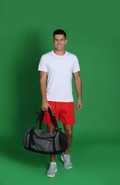 Photo of Handsome man with sports bag on green background