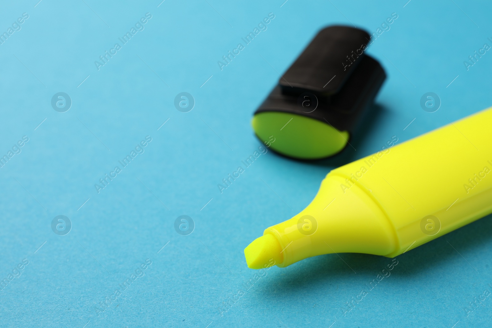 Photo of Bright yellow marker on light blue background, closeup. Space for text