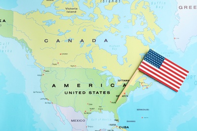 Photo of Little national flag near USA on world map, top view