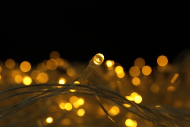 Photo of Glowing Christmas lights on dark background, closeup