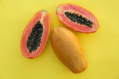 Fresh ripe cut and whole papaya fruits on light green background, flat lay