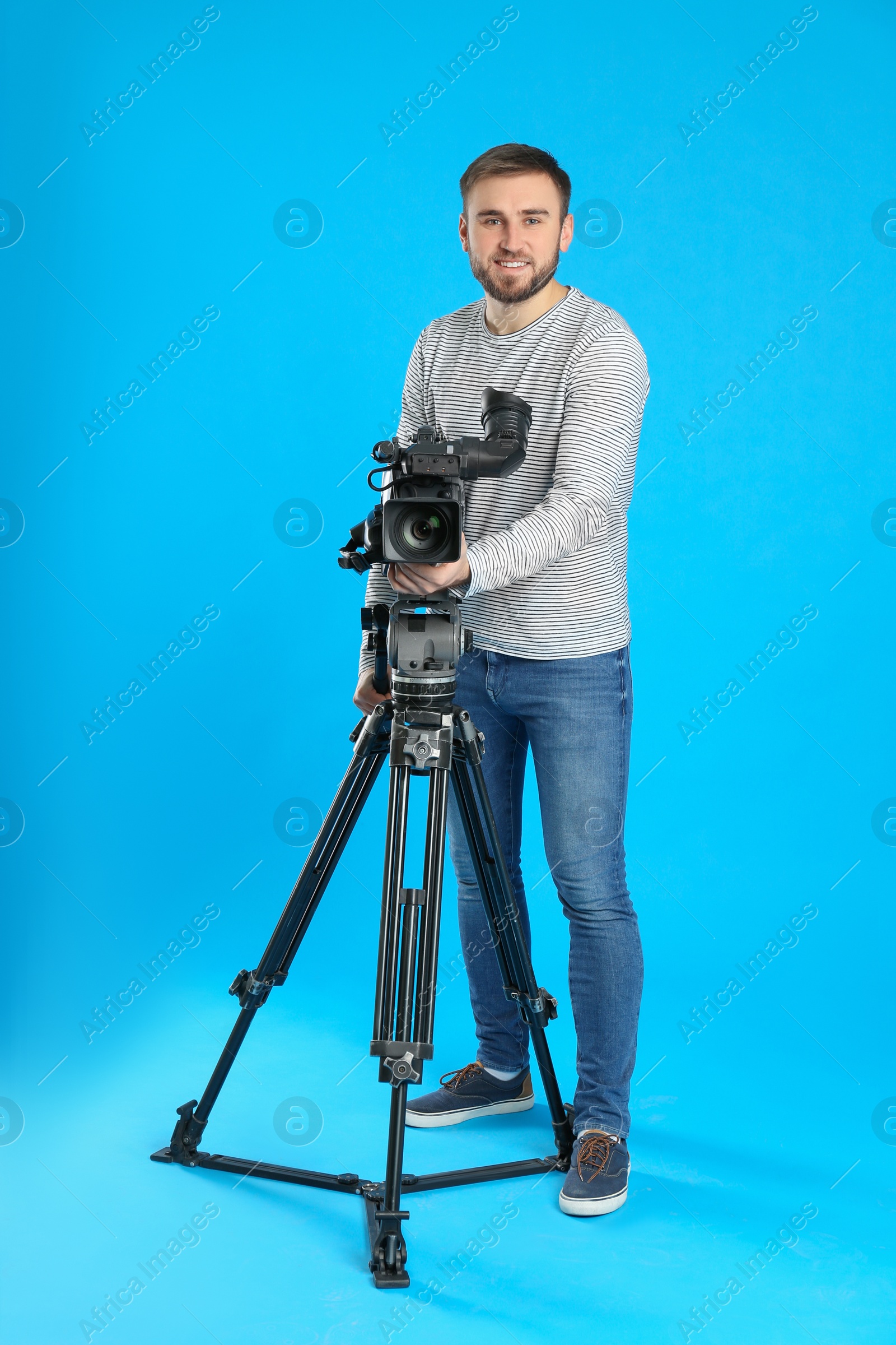 Photo of Operator with professional video camera on blue background