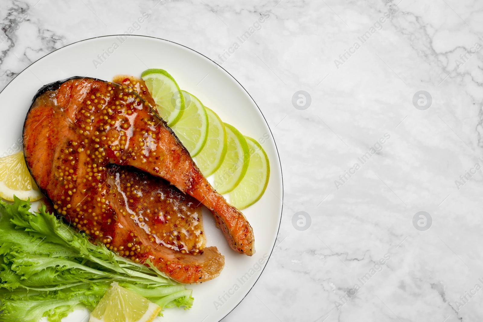 Photo of Tasty salmon steak with sauce, citrus slices and lettuce on white marble table, top view. Space for text