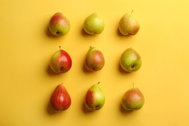 Ripe juicy pears on yellow background, flat lay