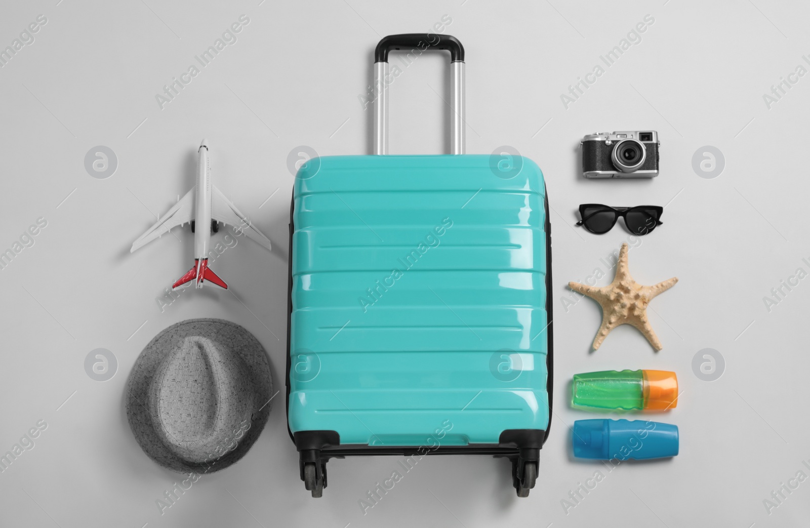 Photo of Flat lay composition with suitcase and travel accessories on grey background. Summer vacation