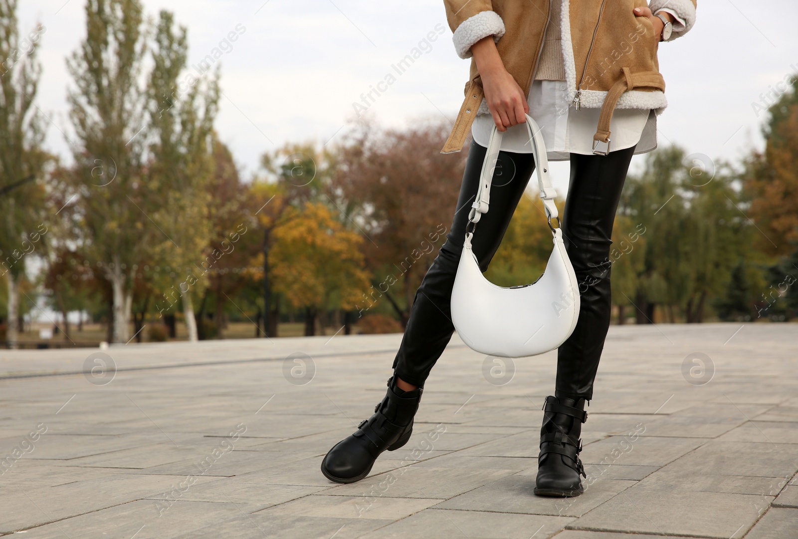 Photo of Stylish woman with trendy white baguette bag on city street, closeup