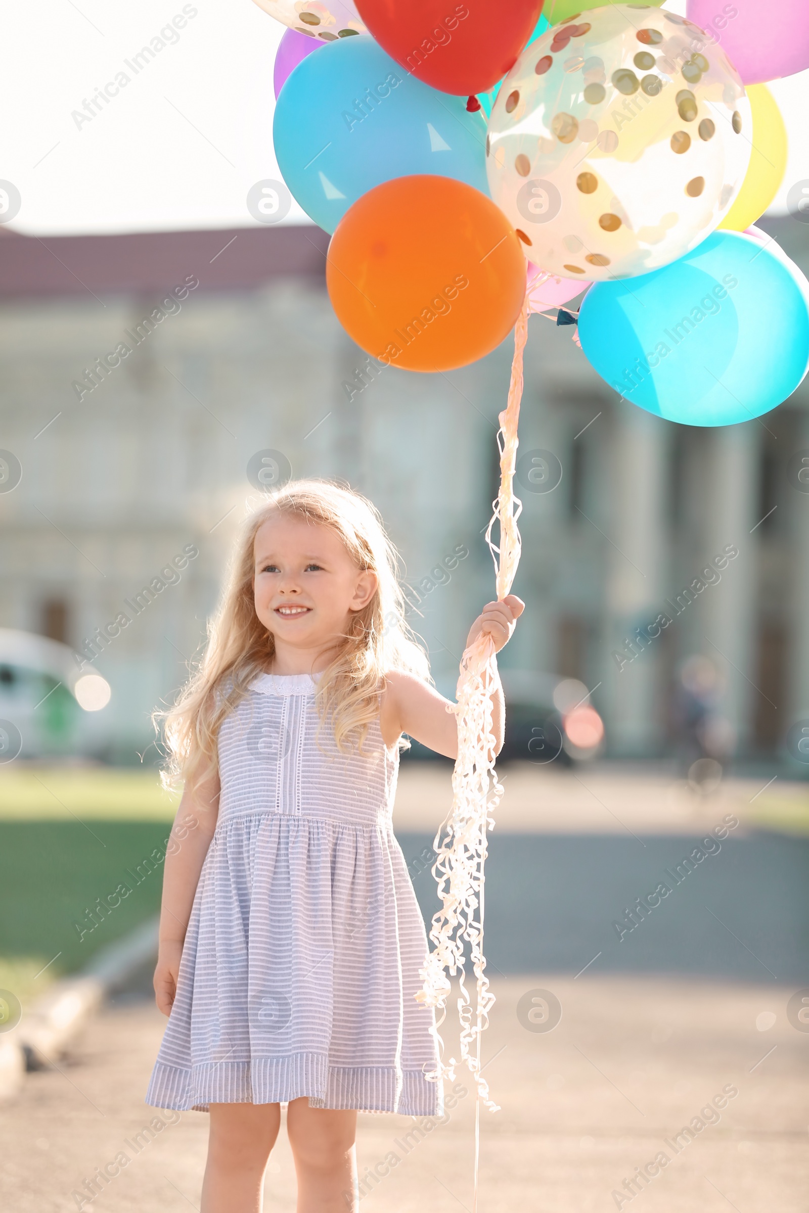 Photo of Cute girl with colorful balloons outdoors on sunny day