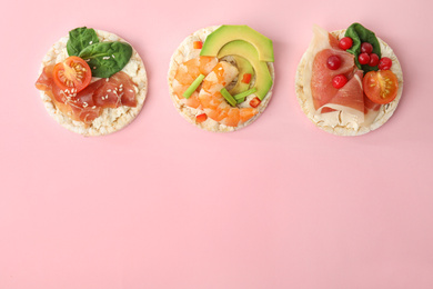 Photo of Puffed rice cakes with different toppings on pink background, flat lay. Space for text