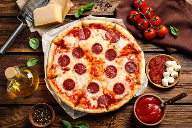 Photo of Flat lay composition with hot pepperoni pizza on wooden table