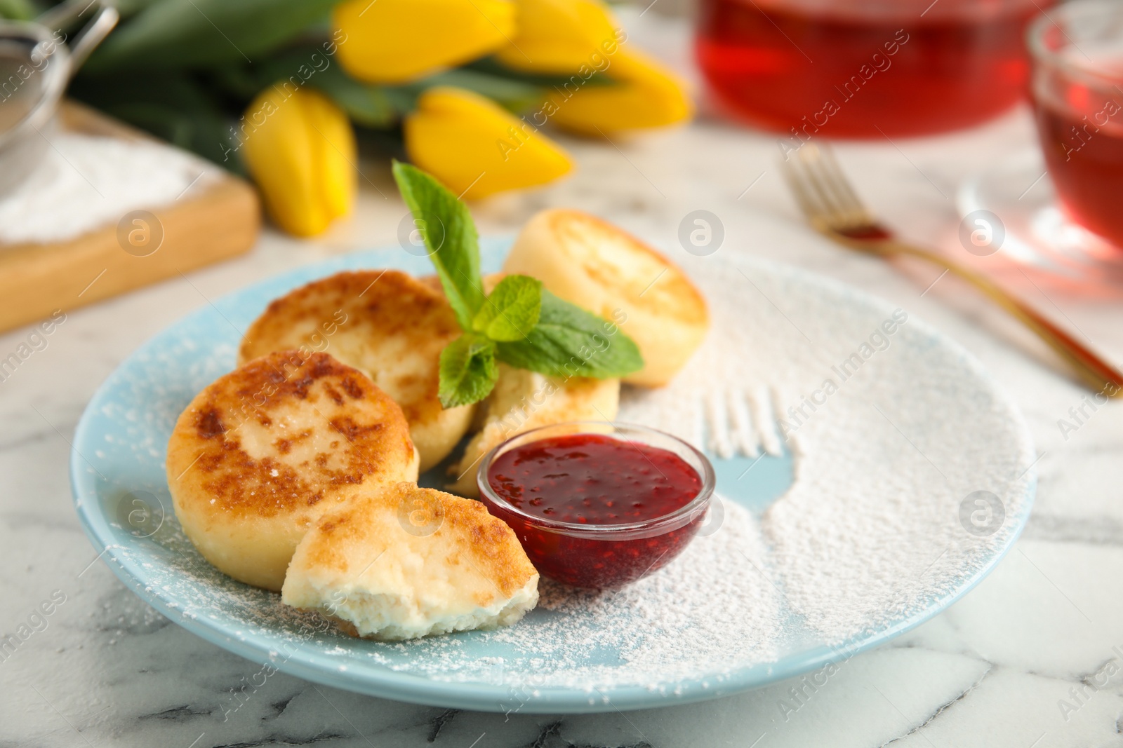 Photo of Delicious cottage cheese pancakes with jam, mint and icing sugar on white marble table