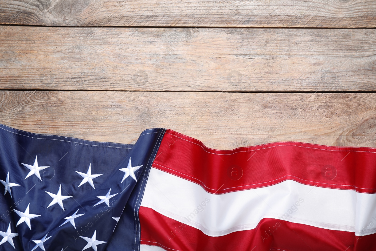 Photo of National flag of America on wooden table, top view. Space for text