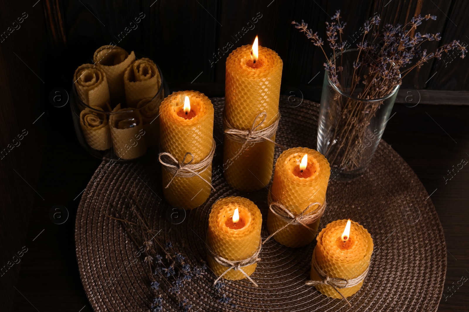 Photo of Beautiful burning beeswax candles and dried lavender flowers on table, above view